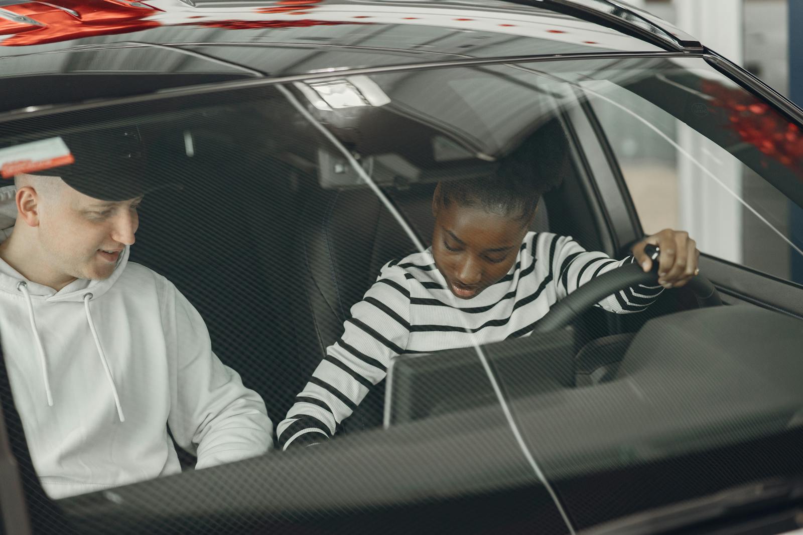 Man in White Hoodie Sitting Inside Car with a Woman